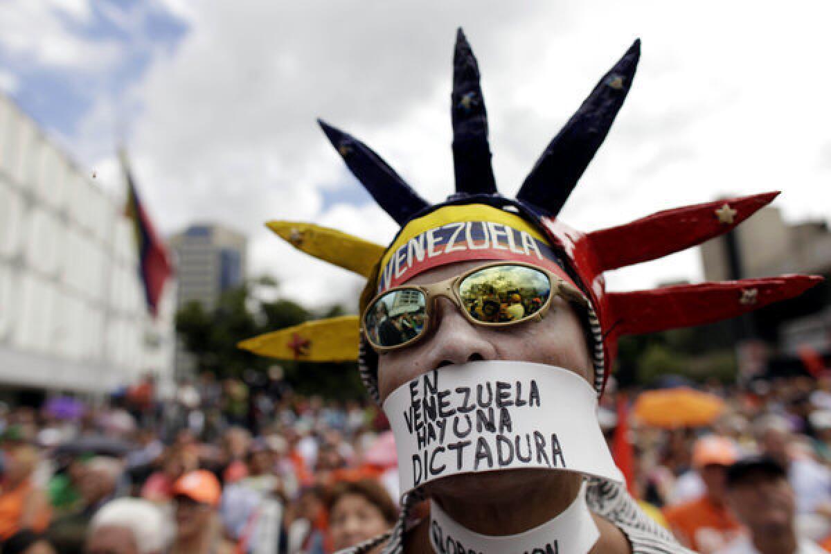 An opponent of Venezuelan President Hugo Chavez wears a message over his mouth that reads in Spanish, "In Venezuela there is a dictatorship," during a gathering Saturday in Caracas, the capital.