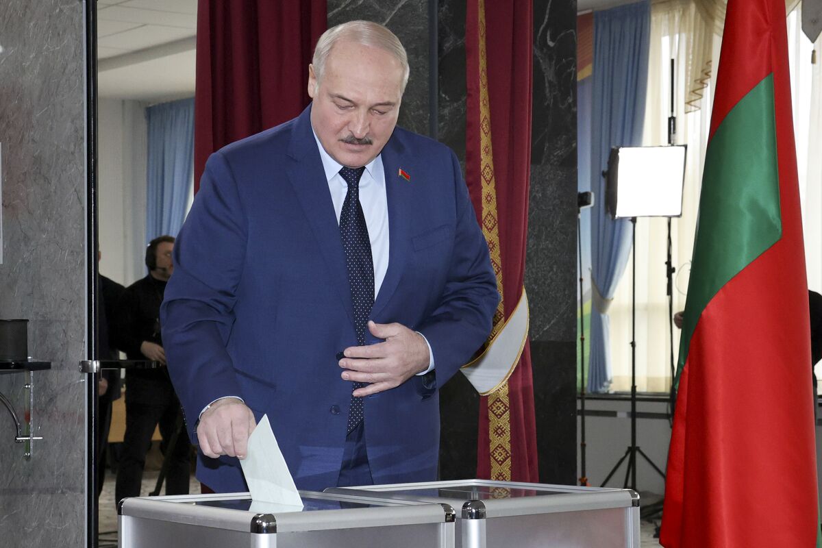 Belarusian President Alexander Lukashenko casts his ballot at a polling station during the referendum on constitutional amendments in Minsk, Belarus, Sunday, Feb. 27, 2022. Belarusians vote at a referendum on constitutional amendments that could allow country's strongman Alexander Lukashenko to further cement his grip on power until 2035. (BelTA pool photo via AP)