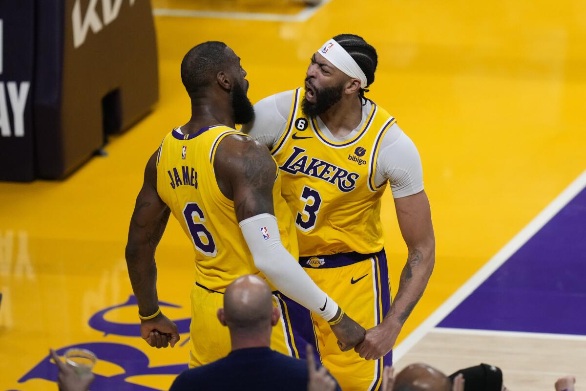 Lakers'ın forveti LeBron James (solda) ve Anthony Davis basket atmayı kutlarken göğüslerine çarpıyorlar.