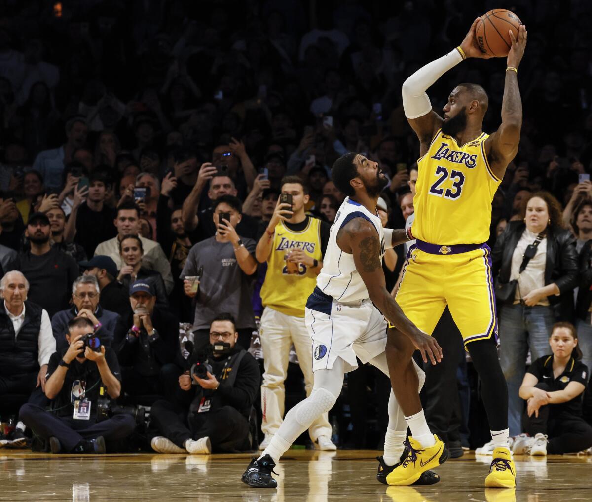 Lakers forveti LeBron James sahaya bakarken topu Mavericks guardı Kyrie Irving'den uzak tutuyor