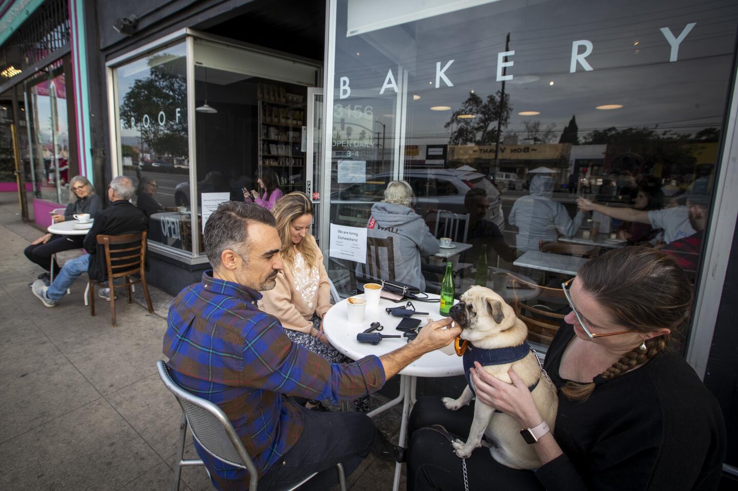 Mike Savas, Lindsay Deaguila, Wally the dog and Emily Wanserski grab a bite to eat in front of Proof Bakery in Atwater Village.