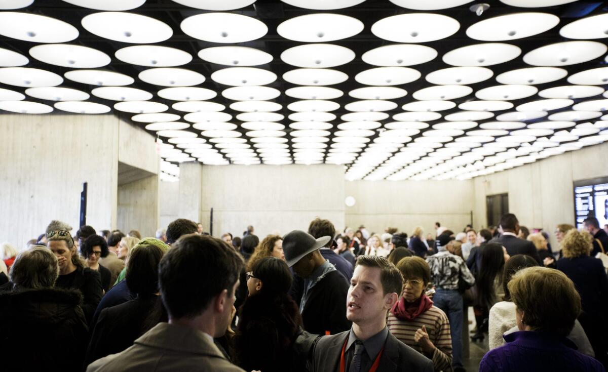 People gather in the lobby of the Met Breuer during the new museum's press preview in New York. The museum opens to the public later this month.