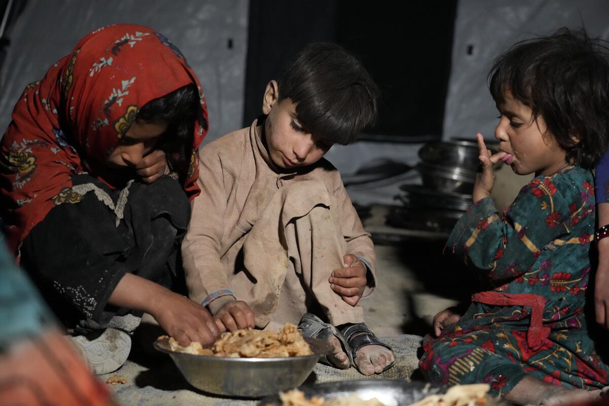ARCHIVOS - Niños afganos comen en un refugio improvisado tras un terremoto 