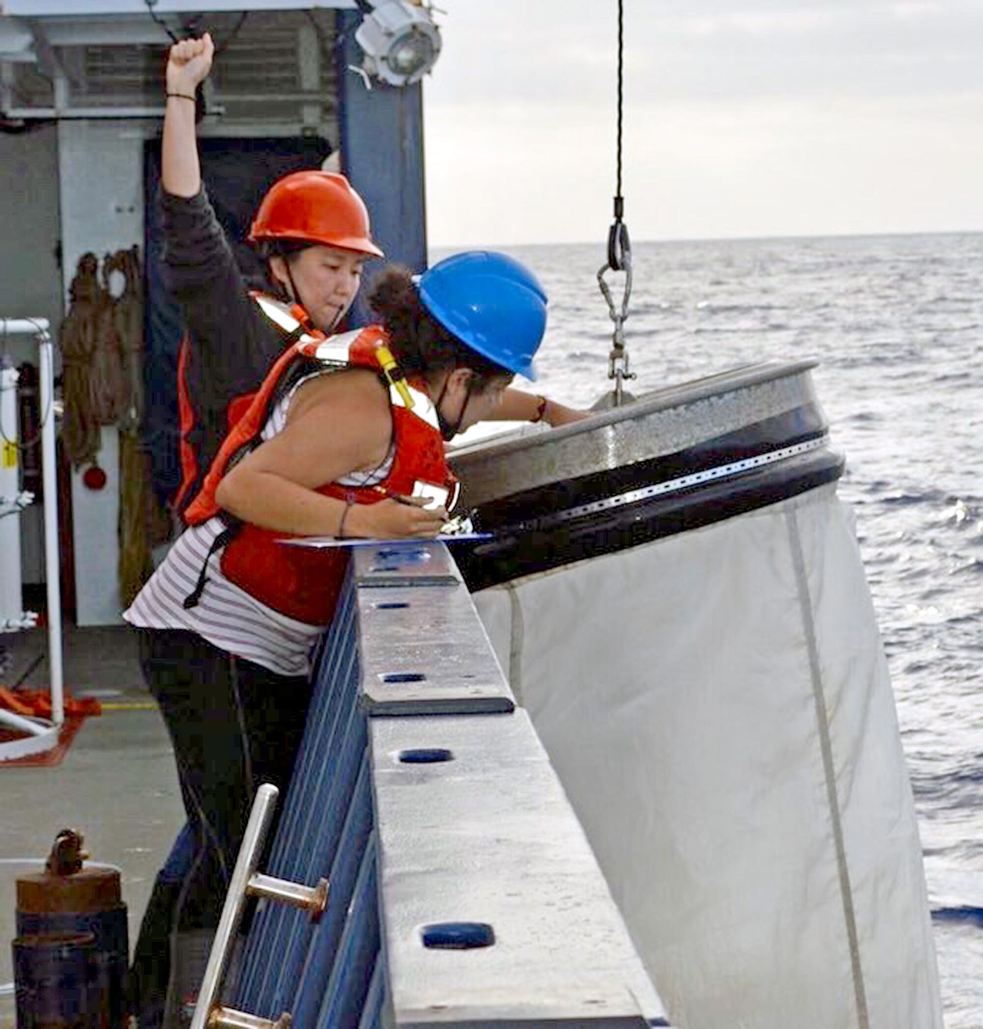 Members of the CalCOFI research team deploy equipment from the ship.