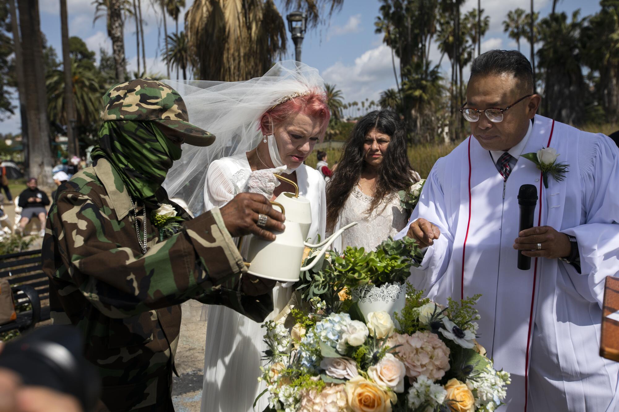  Henry, Valerie Zeller, bridesmaid Ana Vega, and Pastor Billy Roe, conclude the wedding ceremony.