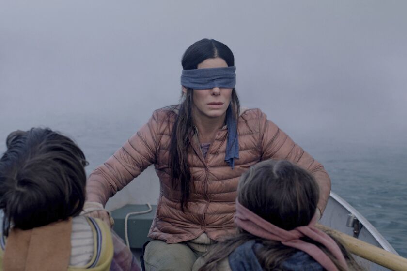 Sandra Bullock plays a woman trying to guide two small children (Julian Edwards, left, and Vivien Lyra Blair, right) to safety in the post-apocalyptic thriller "Bird Box." MUST CREDIT: Netflix ** Usable by LA, BS, CT, DP, FL, HC, MC, OS, SD, CGT and CCT **