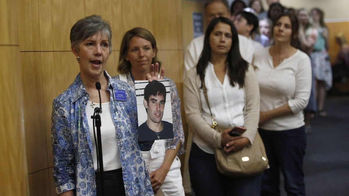 Terry Roark holds a photo of her son, Thomas, who she said was harmed by vaccines given to him as an infant. She was one of many who spoke against a proposal that would require parents in California to get approval from state public health officials to opt out of vaccinations.
