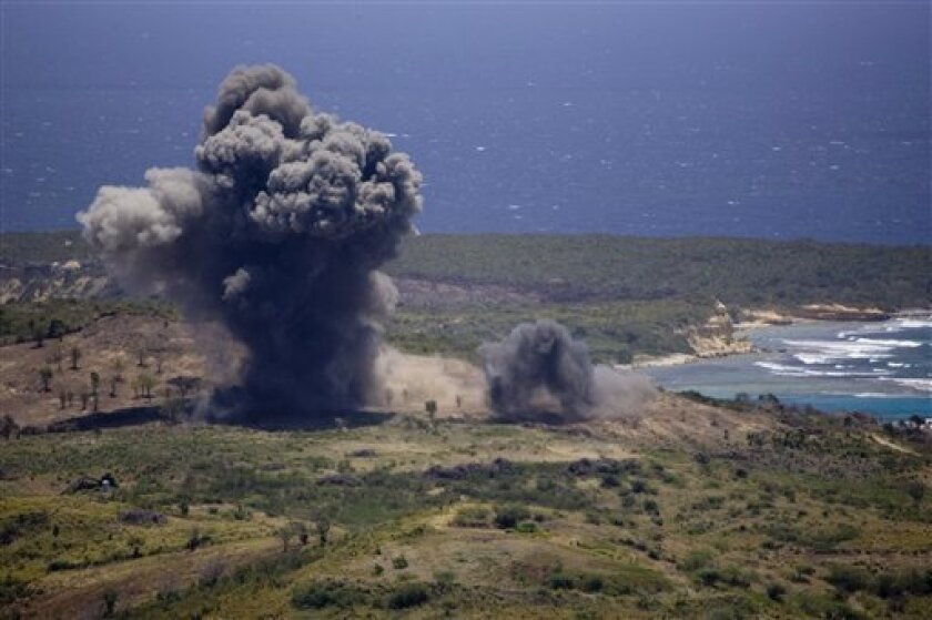 FILE - In this April 17, 2008 file photo, an unexploded ordinance is blown up in a controlled demolition at the former Vieques Naval Training Range, on Vieques island, Puerto Rico. An extensive cleanup of Vieques is underway and the Navy says it's close to finishing work on a former munitions disposal site on the island. It would be a milestone for the cleanup but the plan has sparked criticism. (AP Photo/Brennan Linsley, File)