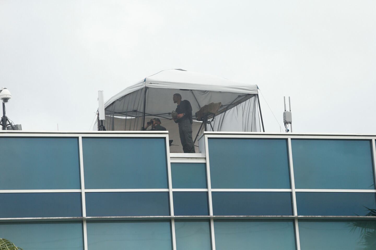 Police on a nearby rooftop monitor the scene at the site of the speech on the University of Florida campus.