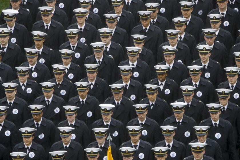 FILE - In this Dec. 14, 2019 file photo, Navy midshipmen march onto field ahead of an NCAA college football game between the Army and the Navy in Philadelphia. A military investigation finds that hand gestures used by cadets and midshipmen during the Army-Navy game broadcast had nothing to do with white supremacy. The investigation, which included interviews and background checks, determined that two freshmen were taking part in a “sophomoric” game that had “no racist intent.” (AP Photo/Matt Rourke, File)