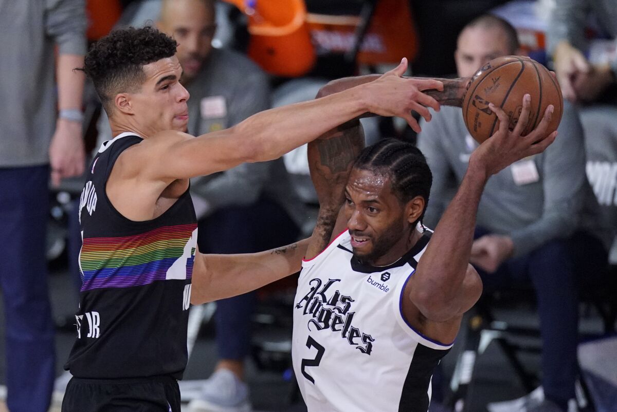 Clippers' Kawhi Leonard is defended by Denver Nuggets' Michael Porter Jr.
