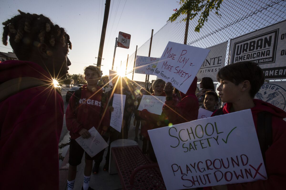 Parents and students gather to protest against a fence nearing completion at Long Beach's Fremont Elementary School, which will close off the campus playground area during non-school hours.