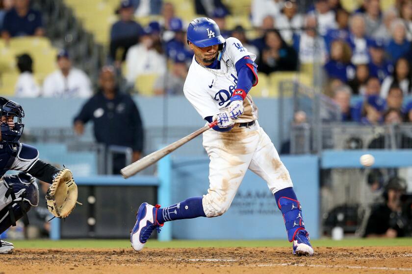 The Dodgers' Mookie Betts swings his bat and connects with the ball during a game against the Yankees