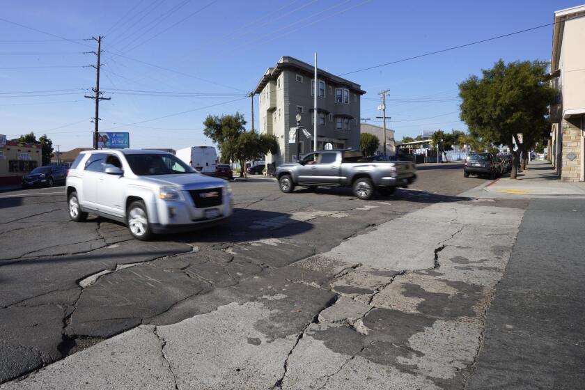 San Diego, CA - January 16: On Tuesday, Jan. 16, 2024, in San Diego, CA, motorists make their way past crumbling asphalt and concrete on the corner of National Avenue and S 26th Street in Barrio Logan. (Nelvin C. Cepeda / The San Diego Union-Tribune)