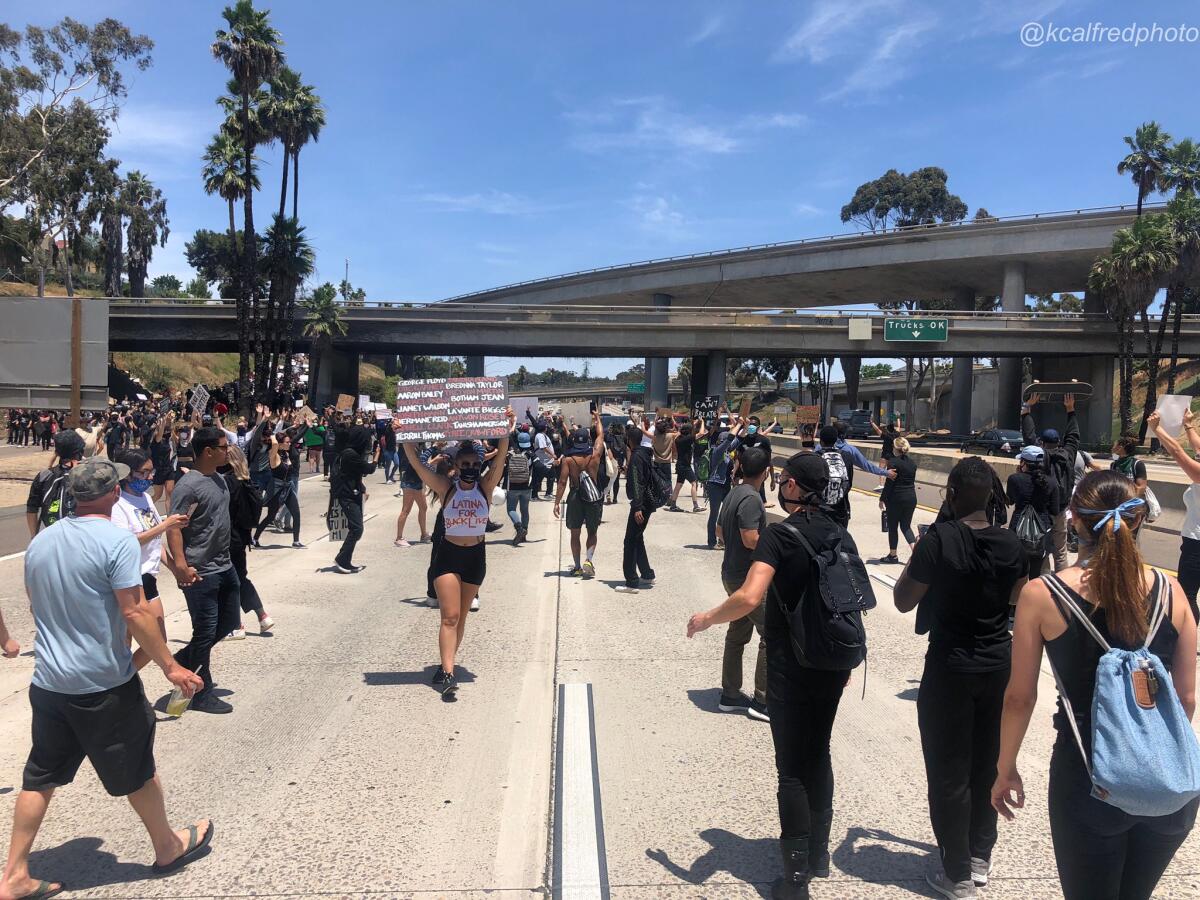 Protesters march Sunday onto Interstate 5 in San Diego.