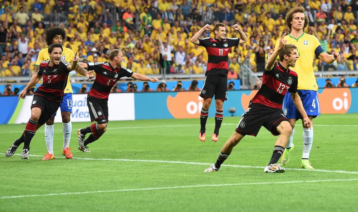 Germany's Thomas Mueller (2-R) celebrates after scoring the opening goal during the FIFA World Cup 2014 semi final match between Brazil and Germany at the Estadio Mineirao in Belo Horizonte, Brazil.