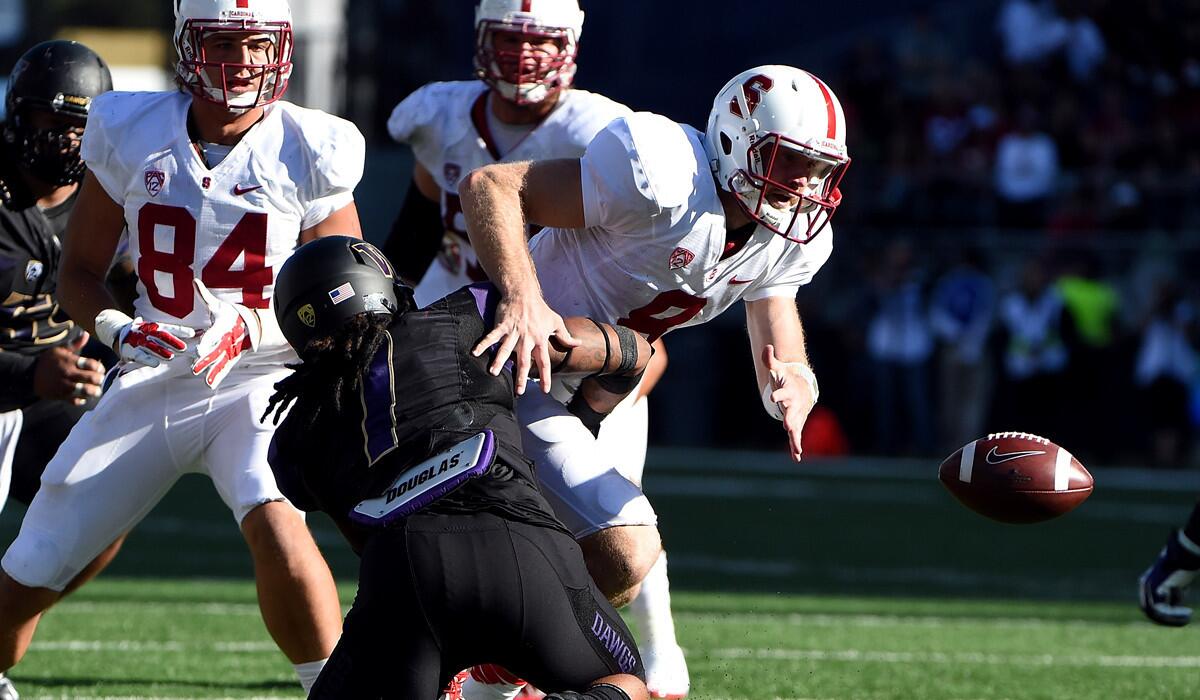 Stanford quarterback Kevin Hogan fumbles the ball as he is hit by Washington linebacker Shaq Thompson in the fourth quarter Saturday.