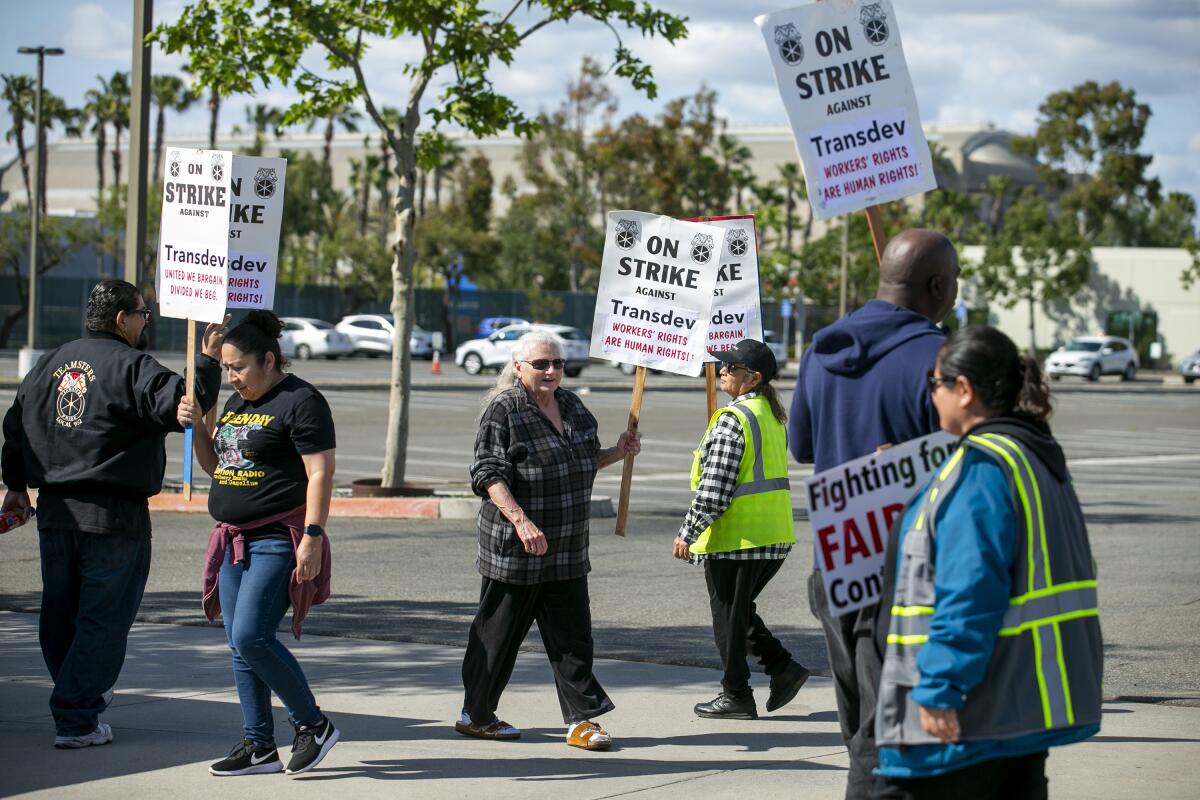 OCTA paratransit drivers, who called a strike Wednesday, march outside their employer's Irvine office on Friday.