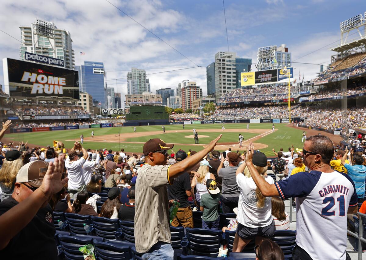 Fans celebrate after Padres' Manny Machado hit a solo home run on Sunday.