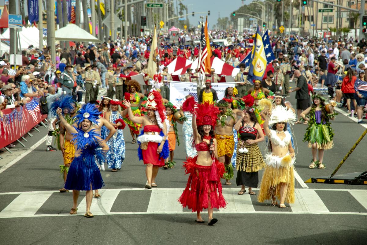 Women from the Kamakani Komohana Polynesian Dance School march in the 2023 H.B. Fourth of July parade.