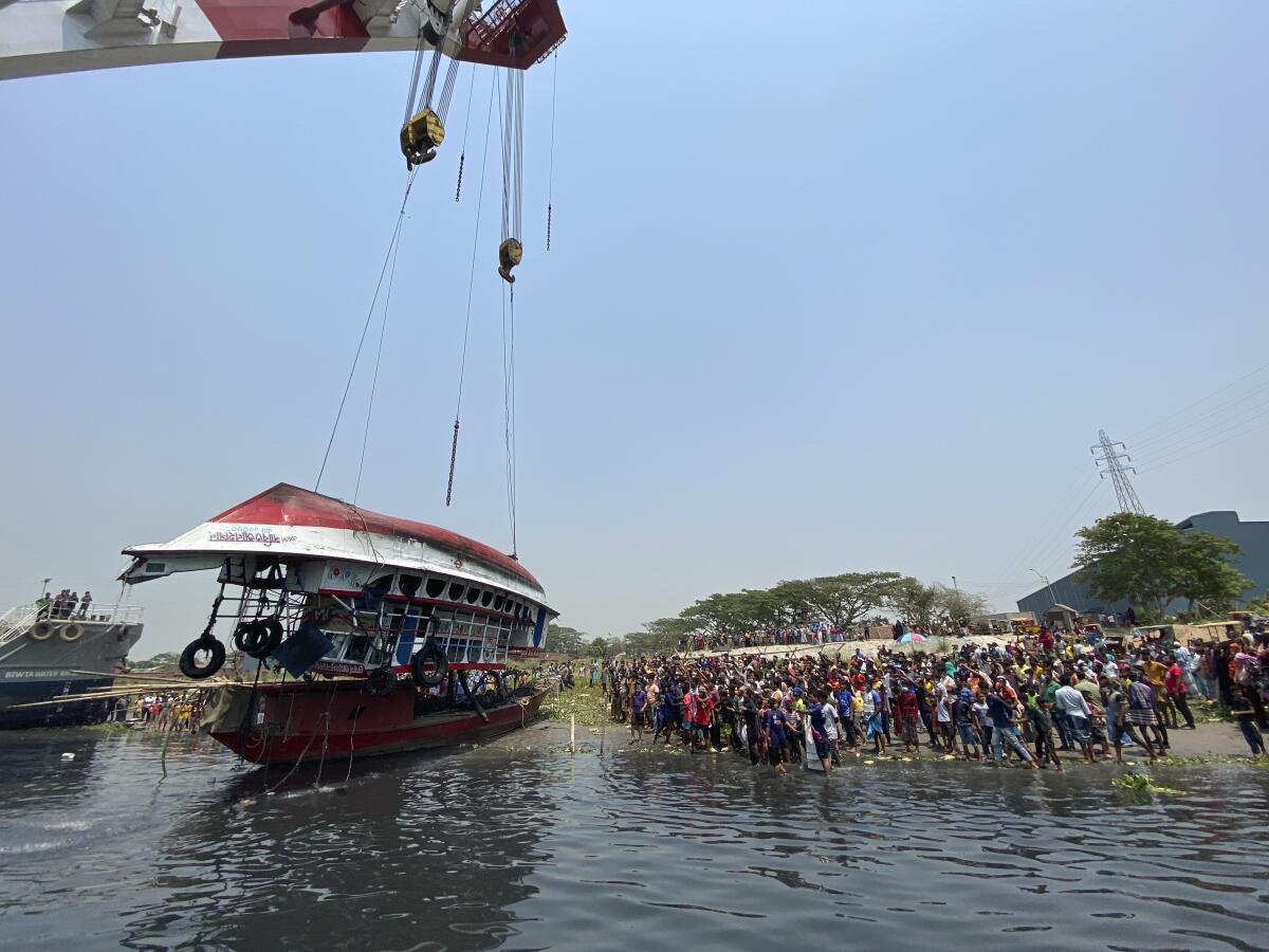 Rescuers pull out a ferry that sank Sunday night after being hit by a cargo vessel in the Shitalakkhya River in Narayanganj district, outside Dhaka, Bangladesh, Monday, April 5, 2021. 25 bodies were recovered as on Monday. (AP Photo/Mushfiqul Alam)