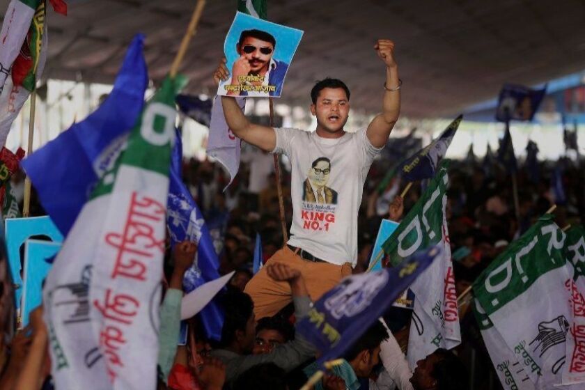 A participant displays a picture of Dalit leader Chandrasekhar Azad as supporters of Bahujan Samaj Party (BSP), Samajwadi Party (SP) and Rashtriya Lok Dal (RLD) gather during an election rally in Deoband, Uttar Pradesh, India, Sunday, April 7, 2019. Political archrivals in India's most populous state rallied together Sunday, asking voters to support a new alliance created with the express purpose of defeating Prime Minister Narendra Modi's ruling Hindu nationalist Bharatiya Janata Party. (AP Photo/Altaf Qadri)
