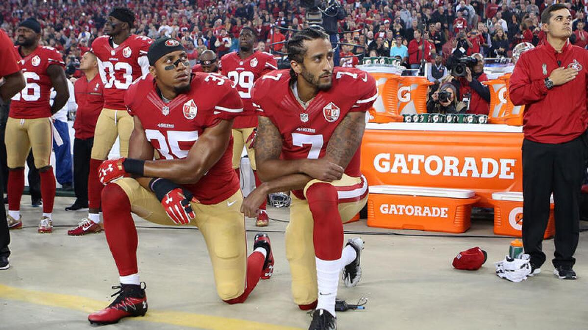 San Francisco 49ers quarterback Colin Kaepernick and Eric Reid, left, take a knee during the national anthem in a 2016 game against the Rams.