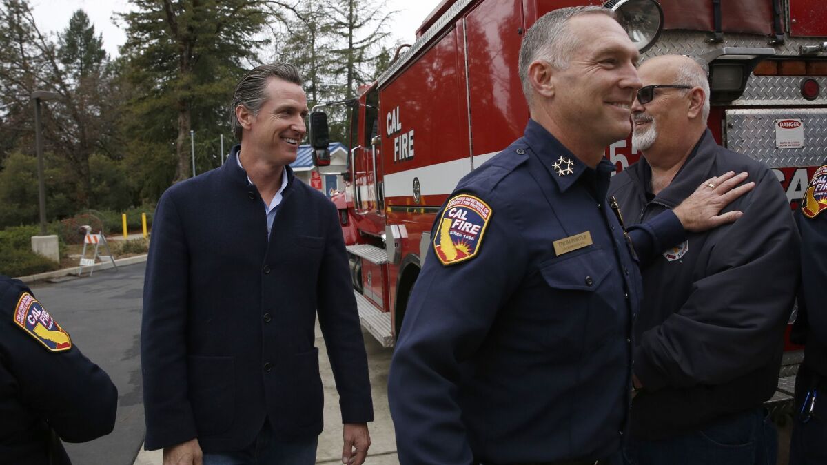 Gov. Gavin Newsom is escorted by Thom Porter, right, to the CalFire Colfax Station in Northern California on Jan. 8. Newsom appointed Porter as director of the Department of Forestry and Fire Protection. He had been serving as interim director.