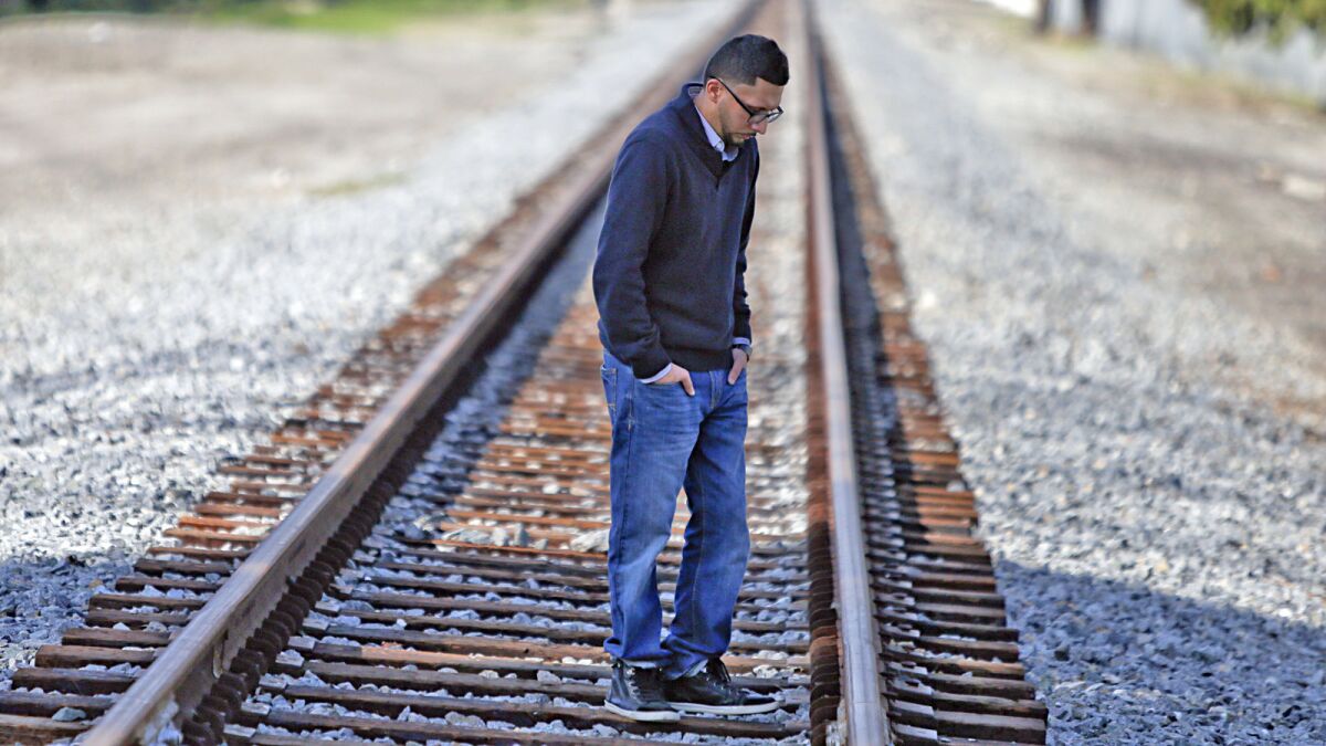 Kris Ramiriez stands on the railroad tracks in Paramount near where his brother, Oscar Ramirez, was killed by deputies in October.