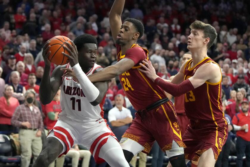 Southern California forward Joshua Morgan (24) and guard Drew Peterson (13) pressure Arizona center Oumar Ballo during the second half of an NCAA college basketball game, Thursday, Jan. 19, 2023, in Tucson, Ariz. (AP Photo/Rick Scuteri)