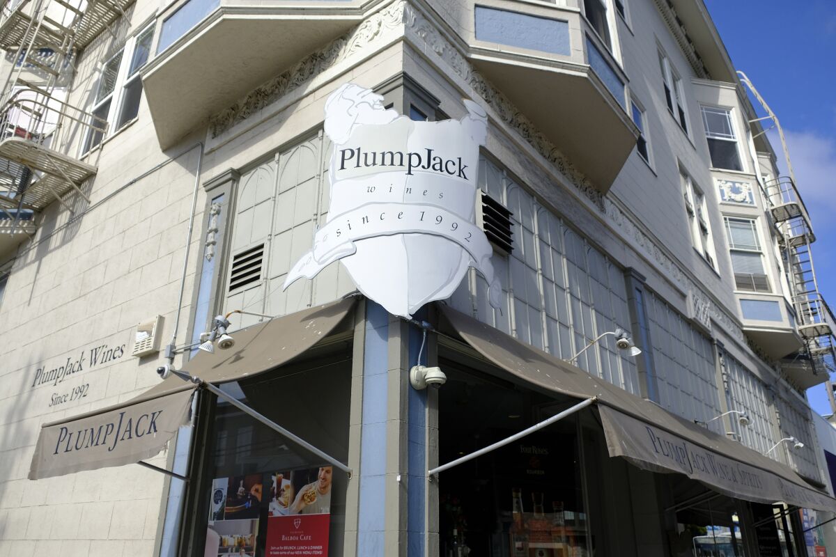 A sign on the corner of a city building says PlumpJack Wines, since 1992