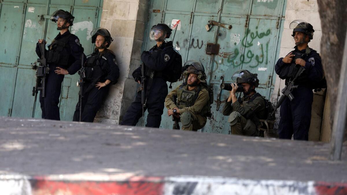 Israeli army soldiers take position during clashes with Palestinian stone throwers in the West Bank city of Hebron on Aug. 10.
