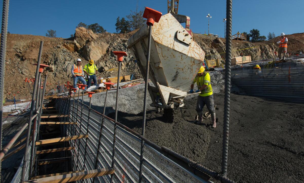 Leveling concrete is delivered from a large bucket attached to a crane on the lower chute of the Lake Oroville flood control spillway on July 14.