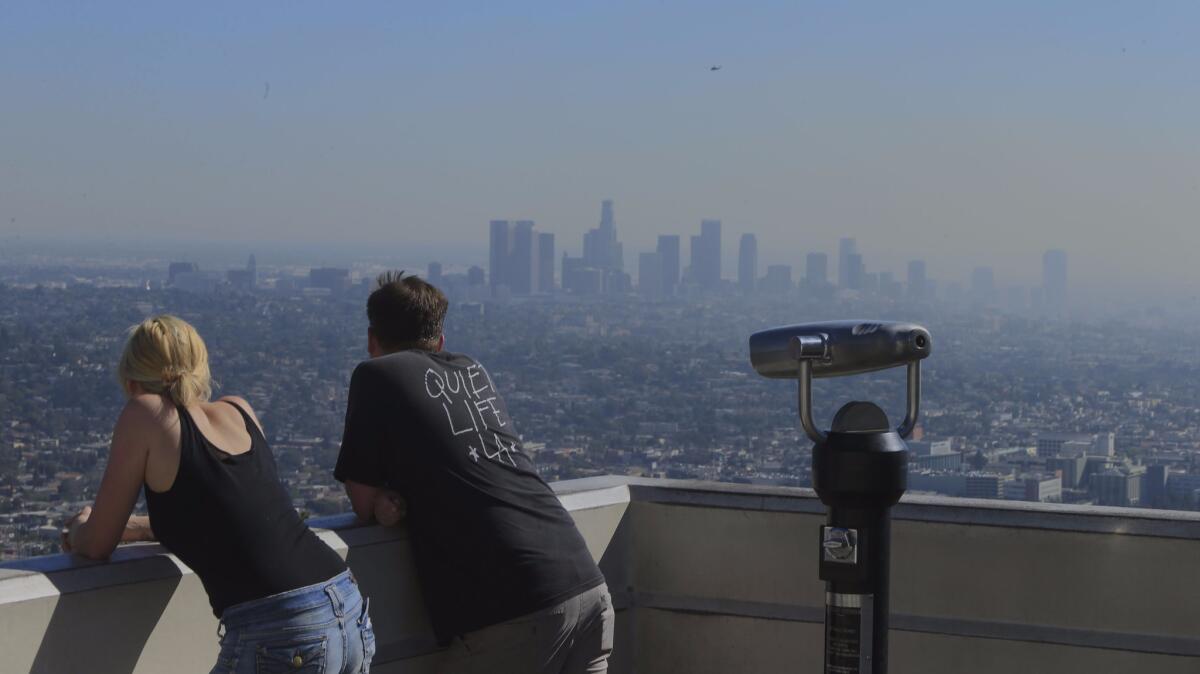 Visitors to Griffith Park take in a smoggy L.A. Basin. A report warned that Southern California could face rolling blackouts this summer if gas supply is curtailed after the massive Aliso Canyon leak.