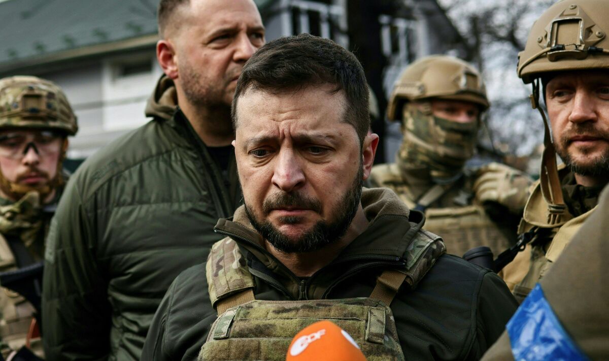 A man in body armor looks devastated as he talks to the press