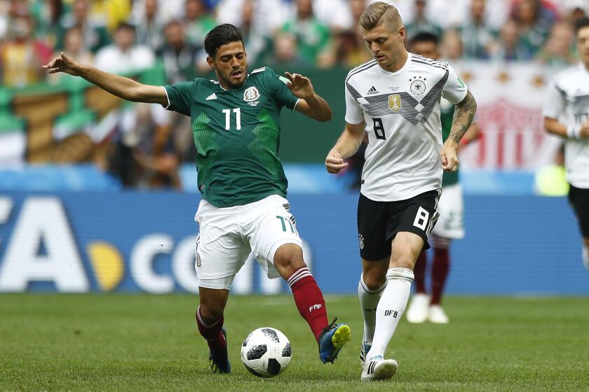 Mexico's Carlos Vela, left, and Germany's Toni Kroos challenge for the ball during the group F match between Germany and Mexico at the 2018 soccer World Cup in the Luzhniki Stadium in Moscow, Russia, Sunday, June 17, 2018. (AP Photo/Matthias Schrader)