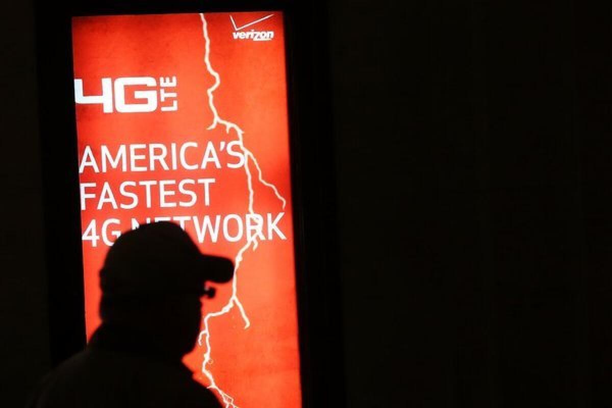 People walk by a Verizon advertisement in New York City.