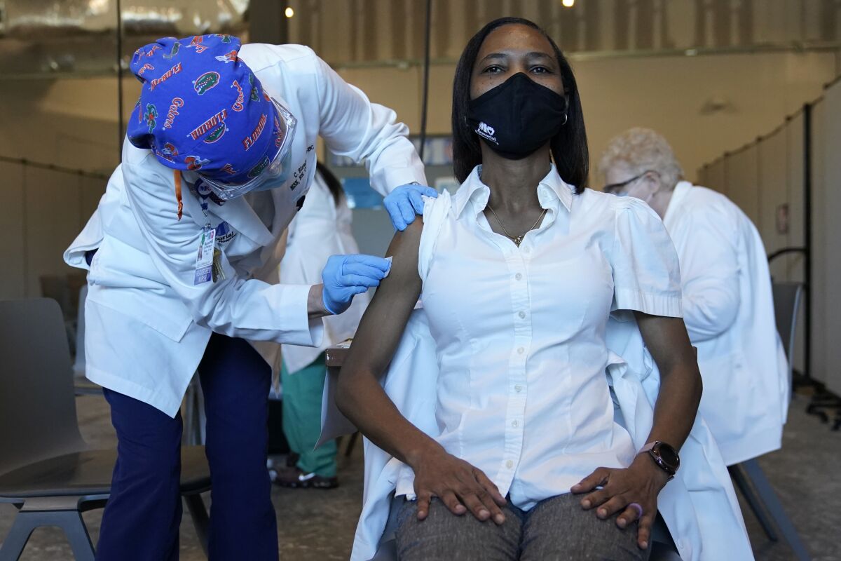 Registered nurse La Tanya Forbes waits to be inoculated with a COVID-19 at Memorial Healthcare System in Miramar, Fla.