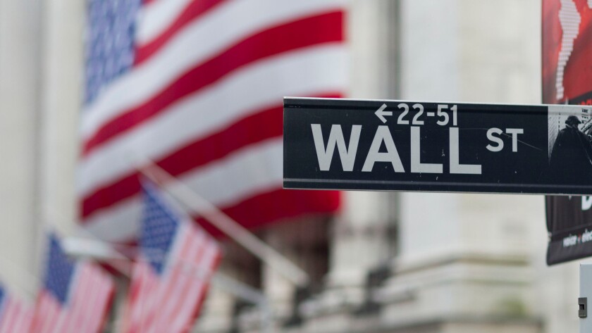 A Wall Street sign hangs near the New York Stock Exchange.
