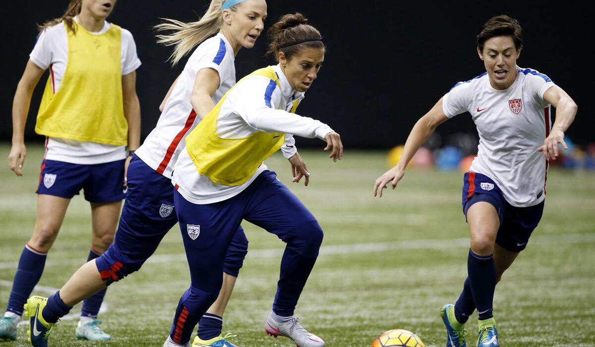 U.S. midfielder Carli Lloyd moves the ball past Meghan Klingenberg, right, and Julie Johnston, behind, during a practice session on Dec. 15.