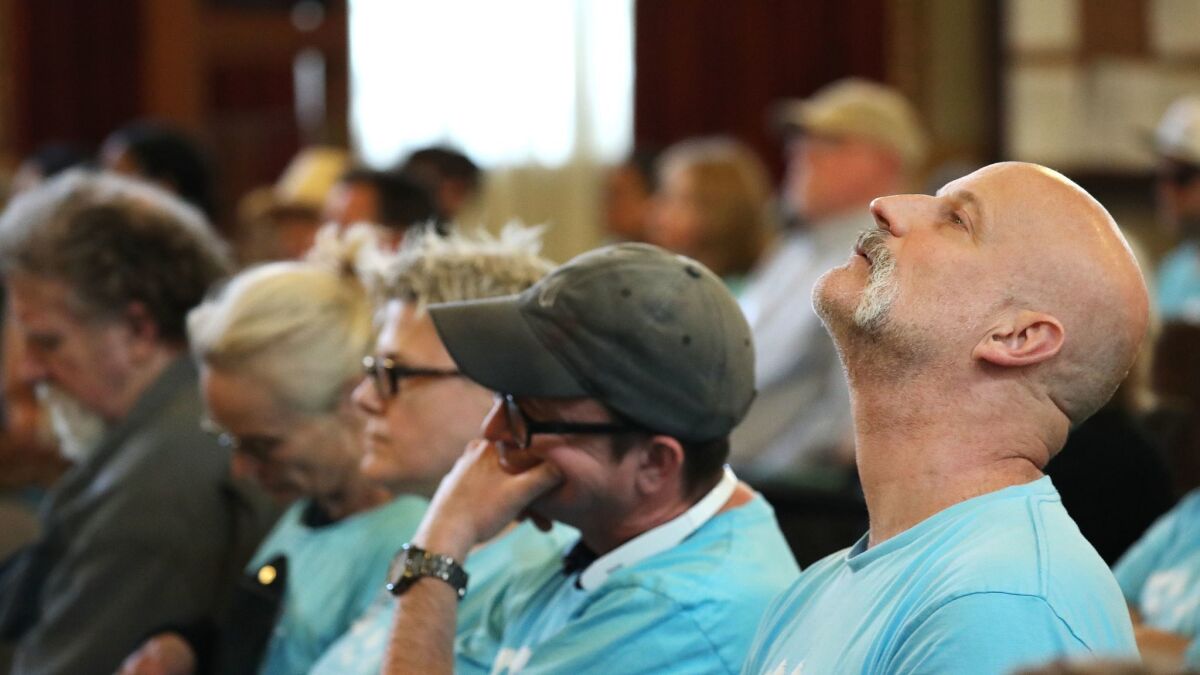 Chris Ganser of Silver Lake, right, who hosts guests through Airbnb at his duplex, attends a Los Angeles City Council committee meeting Tuesday as officials weigh new rules that would legalize and regulate the practice of renting out homes for short stays.