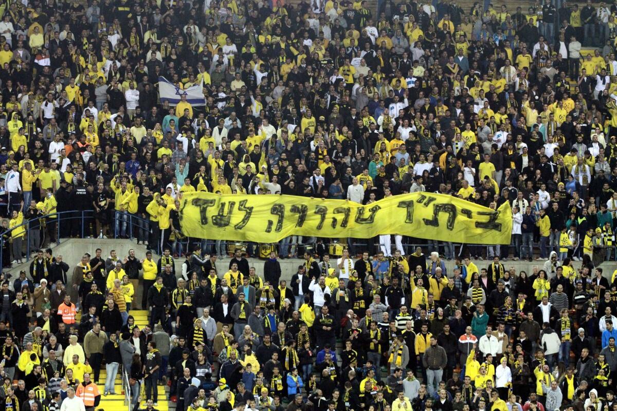 Fans of the Jerusalem football team Beitar Jerusalem hold up a banner that reads in Hebrew, "Beitar Pure Forever" during a match in Jerusalem last year.