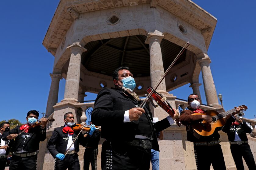 Israel Moreno, center, and Jose Cervantes, right, along with other mariachi musicians join in solidarity asking Los Angeles County officials for economic help during the coronavirus pandemic at Mariachi Plaza in Boyle Heights on Wednesday.
