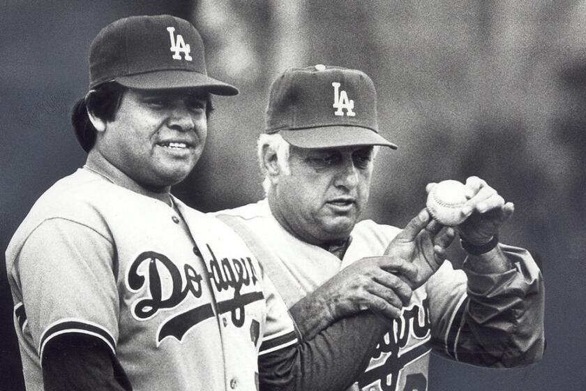 Dodgers manager Tommy Lasorda check the grip of pitcher Fernando Valenzuela during a spring training workout in 1983.