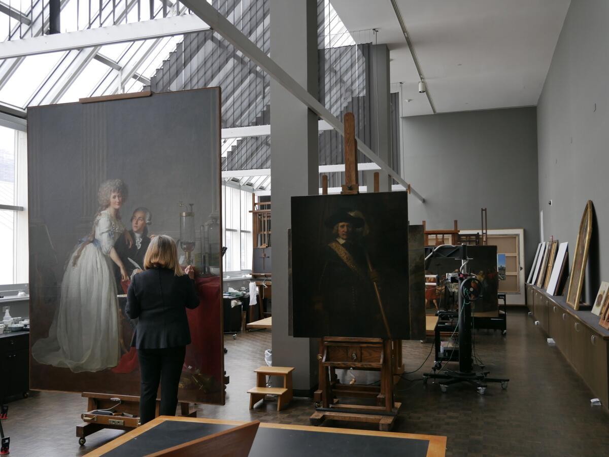 A Met conservator works on a large painting.