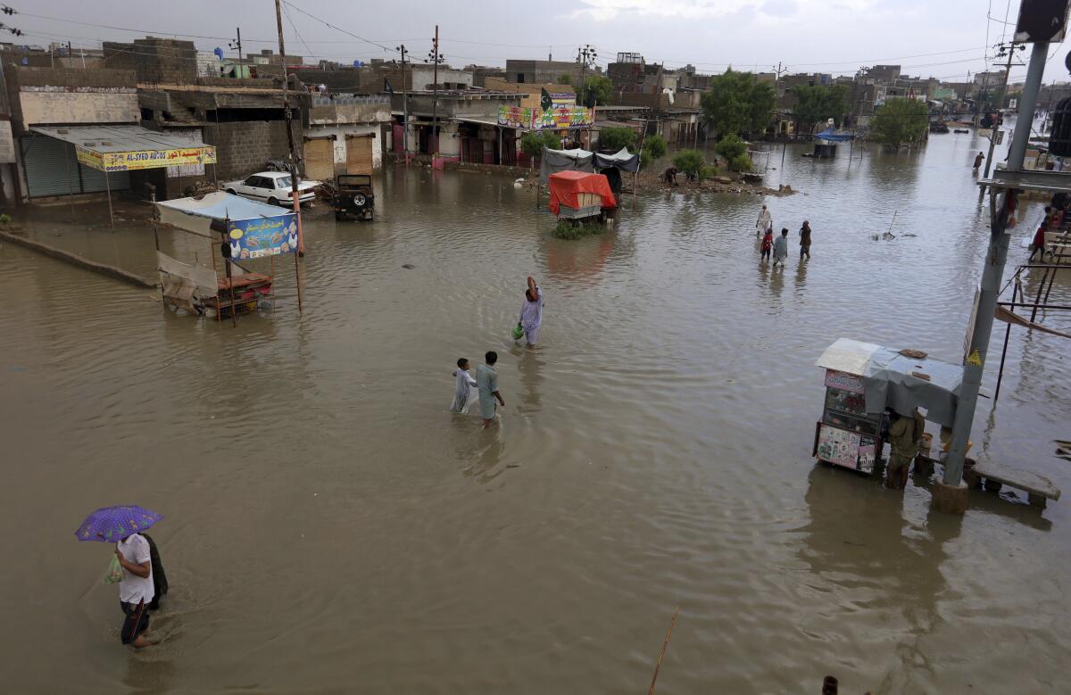 Residents wade through a flooded area caused by heavy monsoon rains, in Karachi, Pakistan, on Friday.