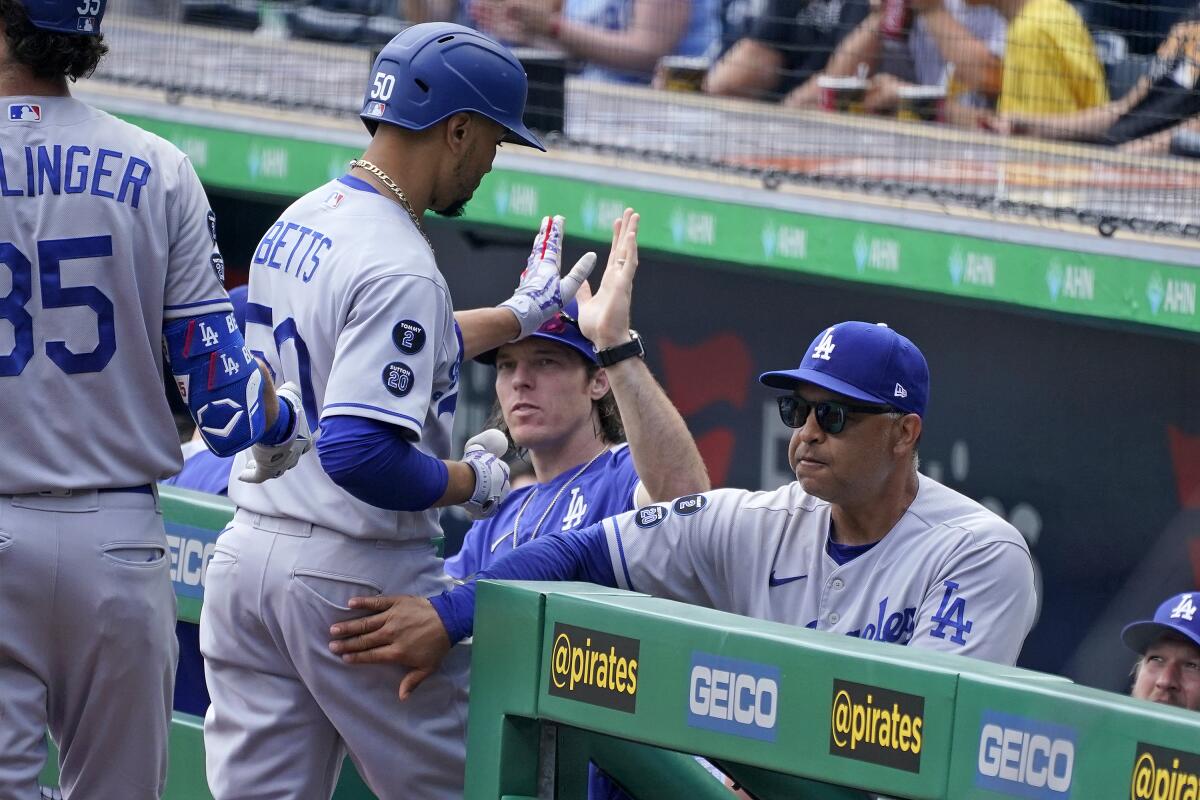 Mookie Betts of the Dodgers is greeted at the dugout Thursday after hitting a home run to lead off against the Pirates.