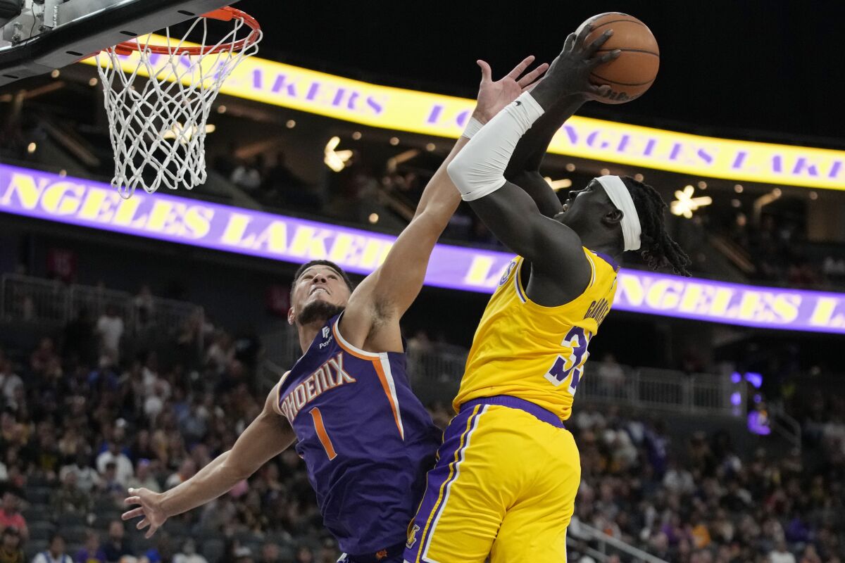 Lakers forward Wenyen Gabriel shoots over Phoenix Suns guard Devin Booker.
