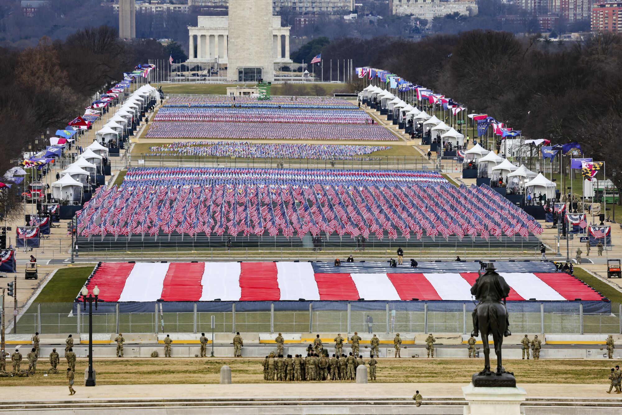 National Guard members look on as U.S. flags adorn the "Field of Flags" at the National Mall.