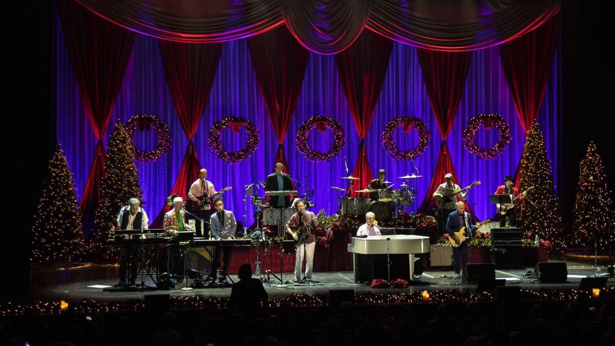 Beach Boys co-founder Brian Wilson, at the piano, sings hits from the Beach Boys' 1964 Christmas album with his band at the Fred Kavli Theatre on Thursday in Thousand Oaks.